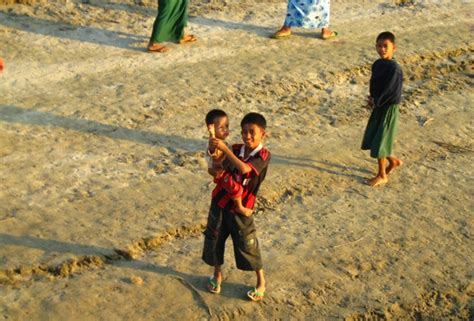Children Look To The Camera Along The Ayeyarwady River Which Flows