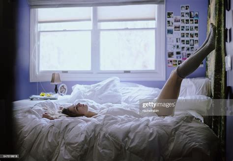 Young Woman Lying On Her Bed With Legs In The Air Photo Getty Images