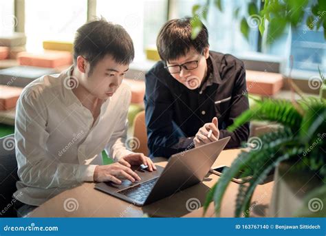 Asian Colleagues Discussing At Workplace Stock Photo Image Of