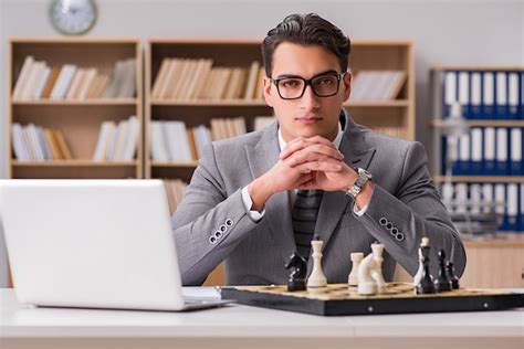 Premium Photo Young Businessman Playing Chess In The Office