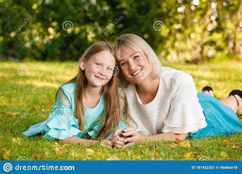 Mom Blonde With Daughter In The Park In Summer In Sunny Weather Stock