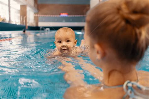 年轻母亲和她的孩子在游泳池里享受婴儿游泳课孩子在水中和高清图片下载 正版图片504002602 摄图网