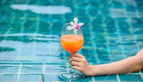 Premium Photo Woman Dink A Cocktail Glass Of Orange Juice At Swimming