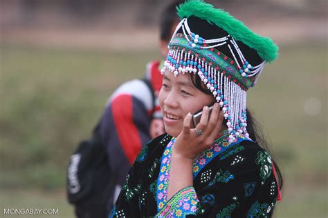 Hmong girl in traditional apparel talking on a mobile while ...