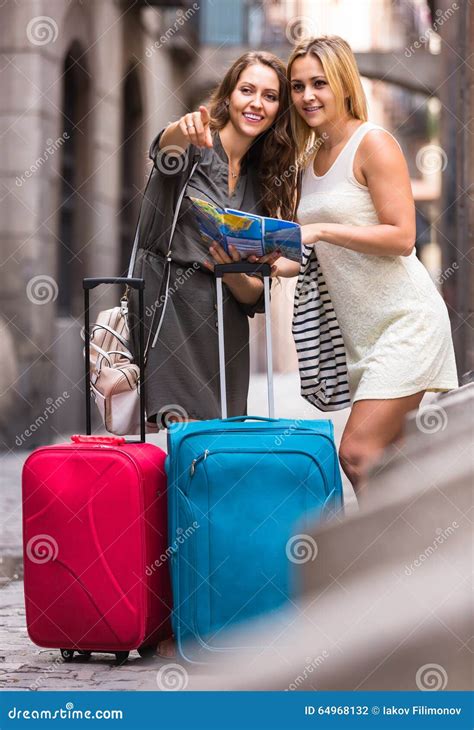 Two Women With Baggage Checking Route Outdoors Stock Photo Image Of