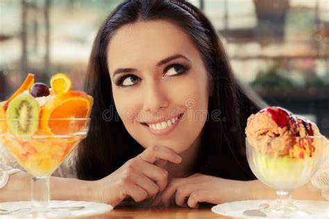 Young Woman Choosing Between Fruit Salad And Ice Cream Desserts Stock