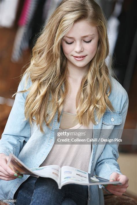 Teenage Girl With Long Blond Hair And Blue Eyes Reading A Magazine High