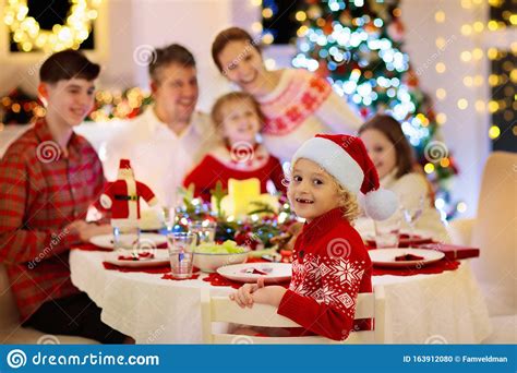 Browse gift guides for mom, the guys, kids, pets, and more. Family With Kids Having Christmas Dinner At Tree Stock Photo - Image of fireplace, daughter ...