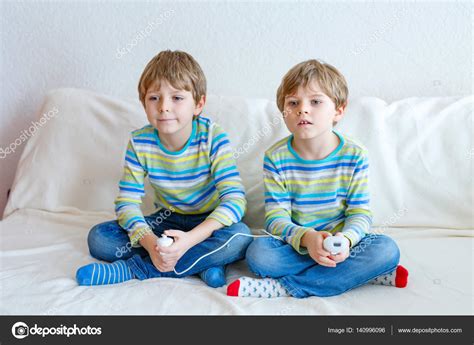 Poco feliz de videojuegos niño jugando. Niños felices jugando videojuegos | Dos poco niños a chicos jugando videojuegos en su casa ...