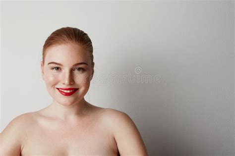 Modelo Femenino Del Pelirrojo Feliz Con El Maquillaje Desnudo Ligero Que Presenta Sobre El Fondo