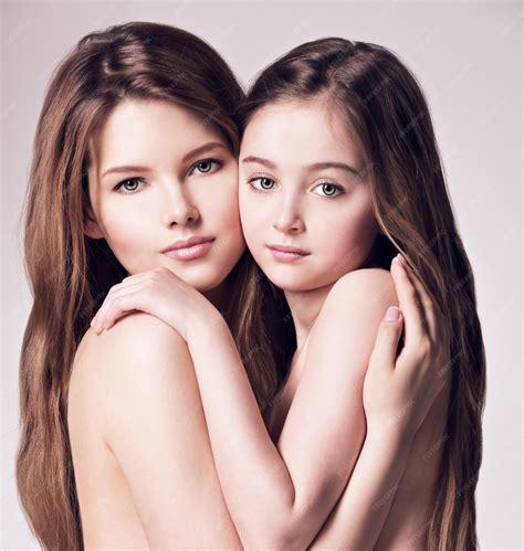 Красивая голая мать и маленькая дочь 8 лет с длинными каштановыми волосами обнимают друг друга в