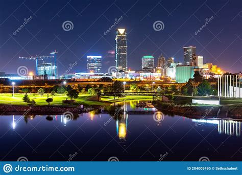 Oklahoma City Skyline At Dusk With Buildings Reflected In Water Stock