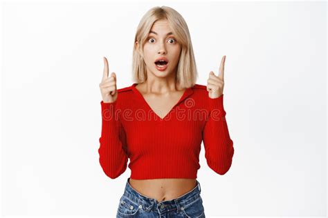 Enthusiastic Blond Girl Pointing Finger Up Smiling And Showing