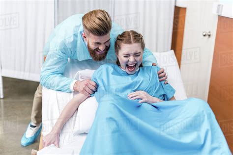 Pregnant Woman Giving Birth In Hospital While Man Hugging Her Stock Photo Dissolve