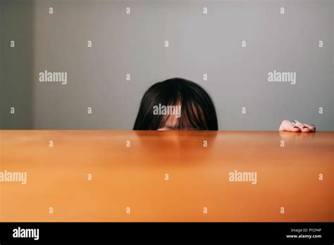 Girl Hiding Behind A Table Stock Photo Alamy