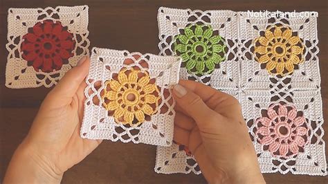 Crocheted Coasters With Colorful Flowers Are Being Held By Someone S Hands