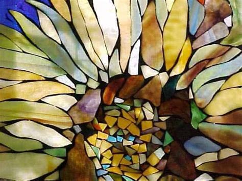 A Close Up View Of A Stained Glass Sunflower With Many Colors And Shapes On It