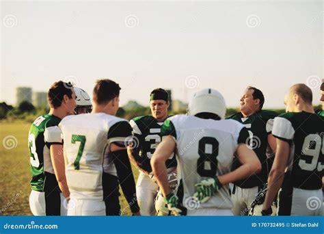 American Football Team Standing In A Huddle Before Practice Stock Image