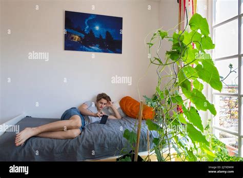 Boy Relaxing On The Bed With Smart Phone Stock Photo Alamy