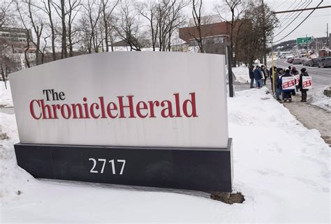A sign for the Halifax Chronicle Herald is seen as members of the ...