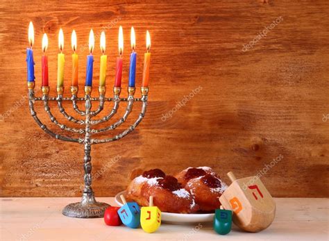 jewish holiday hanukkah with menorah doughnuts and wooden dreidels spinning top retro