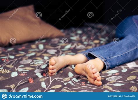 Bare Feet Girl A Girl In Jeans With Bare Feet Is Lying On The Bed