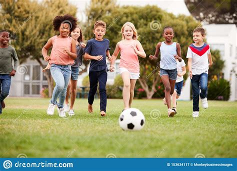 Group Of Children Playing Football With Friends In Park Stock Image