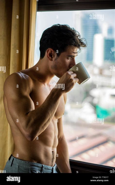 Sexy Young Man Standing Shirtless By Curtains With Coffee Stock Photo
