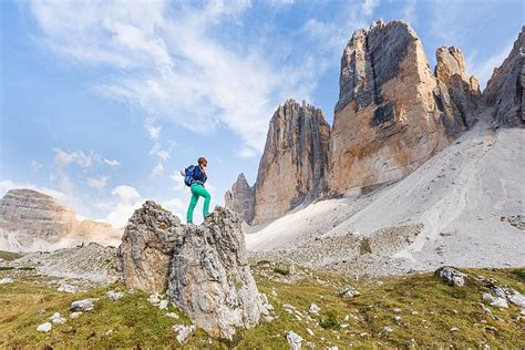 Hiker Stands On Rocks North Faces Of The Three Peaks Of Lavaredo