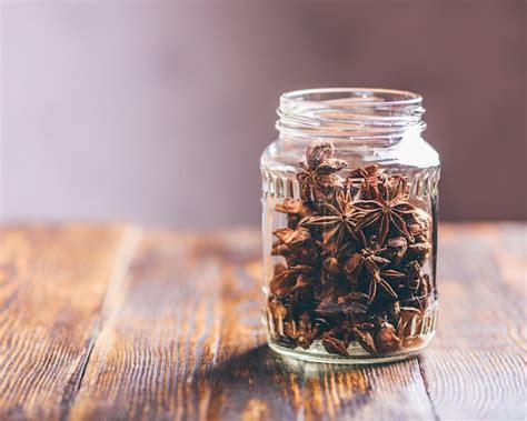 Premium Photo Jar Of Star Anise On Wooden Table