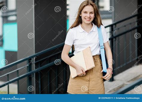 Retrato De Una Estudiante Sonriente Con Un Libro Y Una Mochila Camino A
