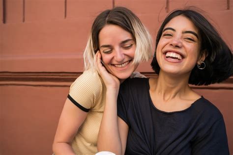 retrato de feliz pareja de lesbianas pasar tiempo juntos y abrazarse en la calle concepto lgbt