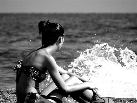 Premium Photo Side View Of Woman Wearing Bikini Sitting At Shore