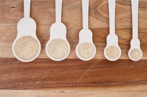 Row Of Plastic Measuring Spoons Filled With Brown Sugar Stock Image
