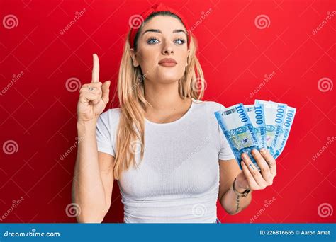 Young Caucasian Woman Holding 1000 Hungarian Forint Banknotes Smiling With An Idea Or Question