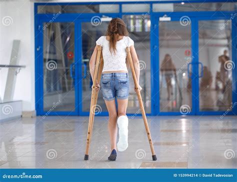 A Young Girl Is On Crutches In The Corridor Of The Hospital Stock Photo