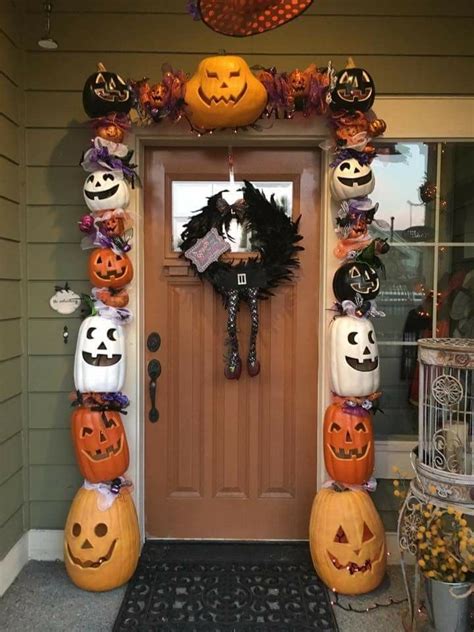 A Front Door Decorated For Halloween With Pumpkins And Jack O Lanterns
