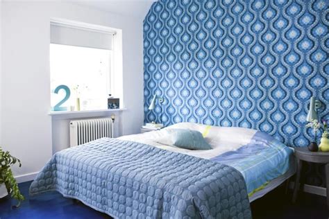 De sterke blåtonene kombinert med ulike mønstre i sengetøy og tapet