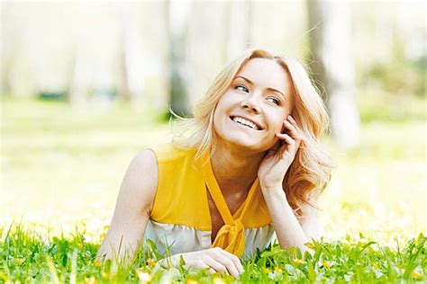 Smilng Happy Young Woman Lying On Green Grass Meadow Background And