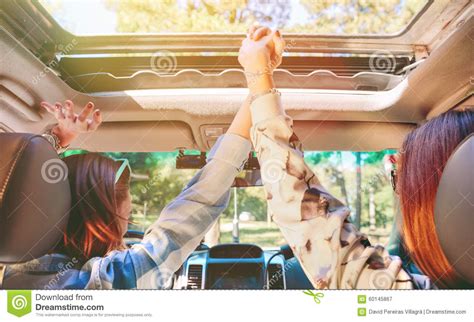 Jumping outside of the box. Happy Women Holding Hands And Raising Arms Inside Stock Image - Image of back, automobile: 60145867
