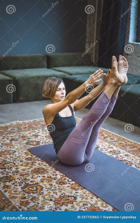 Yogi Female Practicing Yoga Boat Pose On Mat In Vintage Living Room Paripurna Navasana Exercise