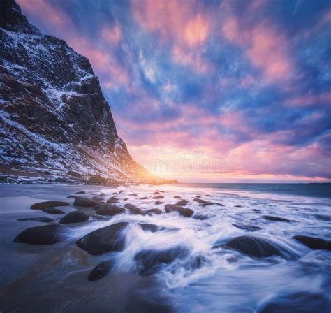 Amazing Sandy Beach With Stones In Blurred Water At Sunset Stock Image