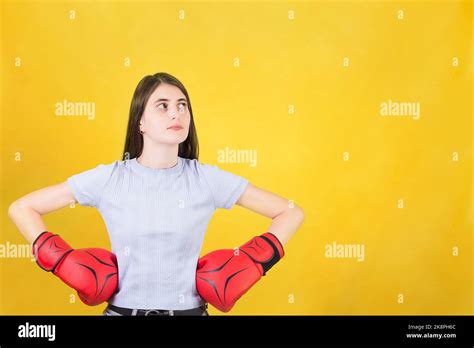 Confident Young Woman With Red Boxing Gloves Stands With Hands On Hips