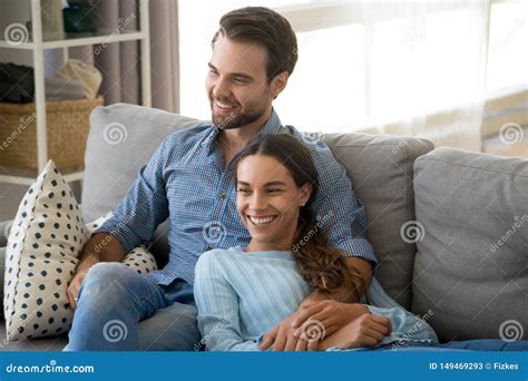 Smiling Couple Relax On Couch Cuddling At Home Stock Image Image Of Excited Lifestyle 149469293