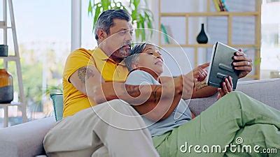 Love Happy And Senior Couple With A Tablet Couch And Bonding On A
