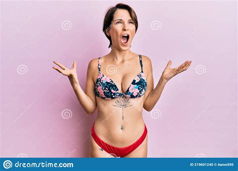 Jeune Femme Brune Aux Cheveux Courts En Bikini Montrant Des Tatouages