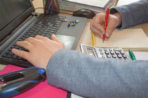 Corporate Businessman Working At Office Desk He Is Using A Calculator