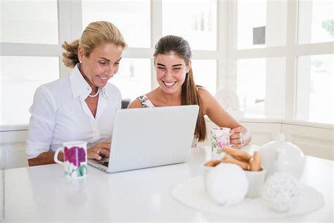 Happy Mother And Daughter Using The Laptop Together Del Colaborador De Stocksy Michela