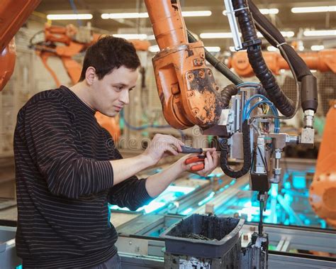 Engineer Performs Maintenance Of Industrial Robot In A Factory Stock