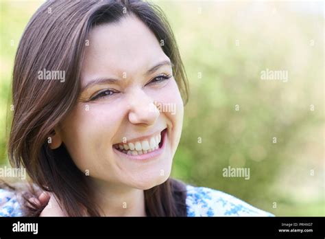 Outdoor Head And Shoulders Portrait Of Laughing Young Woman Stock Photo